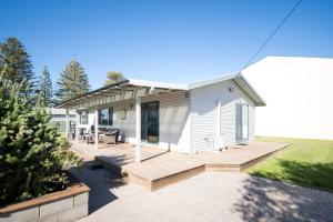 a small white house with a wooden deck at Clearwater Motel Apartments in Esperance