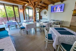 a restaurant with tables and chairs and a tv on the wall at Vila Blue Marine 2 Mai in 2 Mai