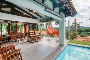 eine Außenterrasse mit einem Pool, einem Tisch und Stühlen in der Unterkunft Villa Sol 35 & 36 in Playa Hermosa