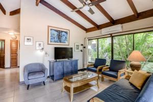 a living room with a couch and chairs and a tv at Villa Sol 35 & 36 in Playa Hermosa
