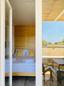 a bed in a room with a large window at Olive Tree Homes in Ios Chora