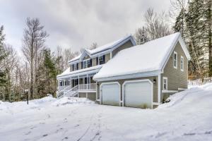 a house with a snow covered driveway in front of it at Moose Lodge in Newry