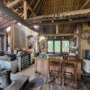 a large kitchen with a table and chairs in it at Villa Cetok Syariah - Nuansa Pedesaan in Simpen