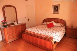 1 dormitorio con 1 cama con tocador y espejo en B&B All'Antica Fonte en Forgaria nel Friuli