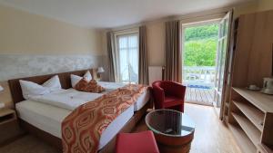 a hotel room with a bed and a large window at Hotel Zum Anker in Neumagen-Dhron