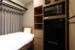 Habitación de hotel con 1 cama, microondas y 1 dormitorio en Dormy Inn Okayama Natural Hot Spring en Okayama