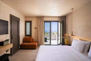 um quarto de hotel com uma cama grande e uma cadeira em On The Square em Pirgos