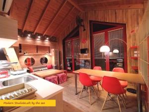 a kitchen and living room with red chairs and a table at MODERN Studio&Loft by the Sea in Epanomi