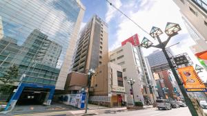 さいたま市にある東横INN大宮駅東口の高い建物と街灯のある街路