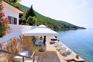 una playa con sillas y una sombrilla junto al agua en Kuća za odmor DRAGA, en Lukovo Šugarje