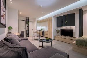 a living room with a couch and a tv at ''THE 58 PROJECT'' in Alexandroupoli