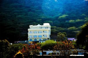 ein großes weißes Gebäude vor einem Berg in der Unterkunft Burj Baneria in Udaipur