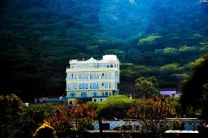 a large white building in front of a mountain at Burj Baneria in Udaipur