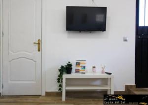 ein Wohnzimmer mit einem TV an einer weißen Wand in der Unterkunft Apartamento Jimena Málaga en el centro de Nerja in Nerja