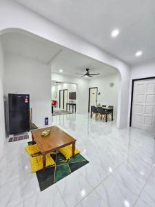 a living room with a table and a dining room at E'dayah Homestay Taman Ria Sungai Petani in Sungai Petani
