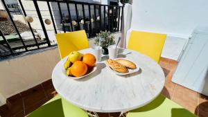 ein weißer Tisch mit zwei Schalen mit Obst und Brot in der Unterkunft Apartamento Jimena Málaga en el centro de Nerja in Nerja