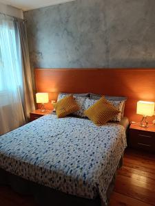 um quarto com uma cama com 2 candeeiros nas mesas em Affittacamere La Loggia em Venzone