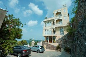two cars parked in front of a building at Burj Baneria - A Boutique Homestay in Udaipur