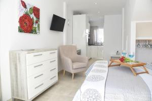 1 dormitorio con 1 cama, vestidor y silla en Estudio Platero, en Nerja