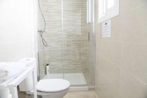 a white bathroom with a shower and a toilet at Ático Platero in Nerja