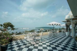 eine Terrasse mit Tischen und Stühlen auf einem karierten Boden in der Unterkunft Burj Baneria in Udaipur