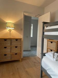 a bedroom with a bunk bed and a lamp on a dresser at Garinish Court Maisonette in Glengarriff