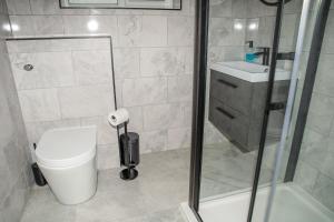 a bathroom with a shower and a toilet and a sink at K Suites - 112 Fulbridge Road OLD in Peterborough