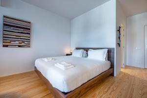 - une chambre avec un grand lit et des draps blancs dans l'établissement Nomads Lux - 1BDR Almada Cool, à Porto