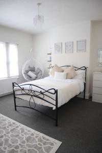 a white bedroom with a bed and a chair at Spacious 1 bedroom apartment in Leicester