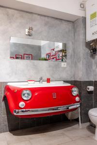baño con lavabo de coche rojo y aseo en Termini Binario 1&2, en Roma