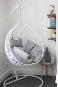 una sedia a dondolo bianca con cuscini in una stanza di Spacious 1 bedroom apartment a Leicester