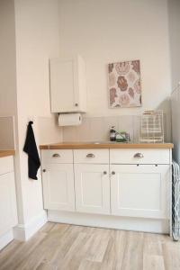 una cucina con armadi bianchi e lavandino di Spacious 1 bedroom apartment a Leicester