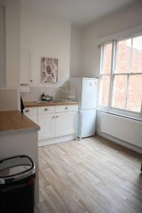 a kitchen with white appliances and a wooden floor at Spacious 1 bedroom apartment in Leicester