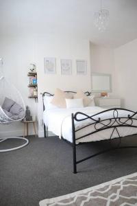 una camera da letto con letto, lenzuola e cuscini bianchi di Spacious 1 bedroom apartment a Leicester