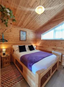 um quarto com uma cama num chalé de madeira em Nature's Nook - Norfolk Broads em Brundall