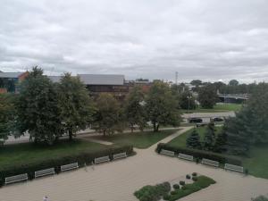 een uitzicht over een park met banken en gebouwen bij City Center Holiday Apartments in Liepāja