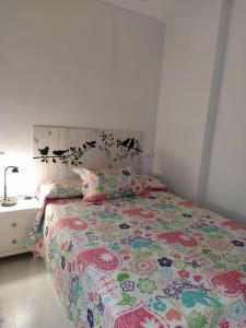 トレビエハにあるMonteagudo - Estudio cerca de Playa del Acequiónのベッドルーム1室(カラフルなベッドカバーと枕付きのベッド1台付)