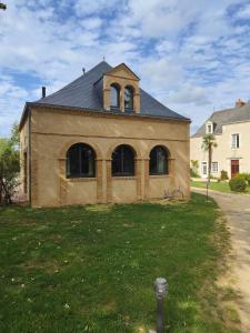 an old building with a clock tower on top of it at LE BAS CHITRAY in Ménil