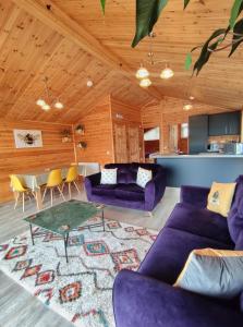 uma sala de estar com sofás roxos e uma mesa em Nature's Nook - Norfolk Broads em Brundall
