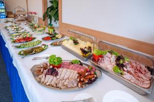 una mesa con muchos tipos diferentes de comida en ella en Zespół Dolina Białego - Pensjonat Biały Potok, en Zakopane