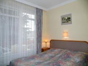 a bedroom with a bed and a large window at Apartment Pension Rideg Heviz in Hévíz