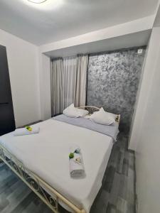 a bedroom with a large white bed with towels on it at Apartament Elysa in Eforie Sud