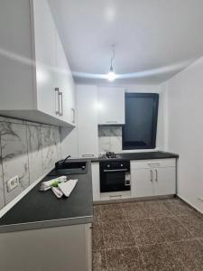 a kitchen with a black counter top and a tv at Apartament Elysa in Eforie Sud