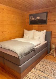 Cama en habitación con paredes de madera en Walser Berghüüsle en Hirschegg
