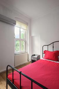 a bedroom with a red bed and a window at Taksim square, galata tower historical flat in Istanbul