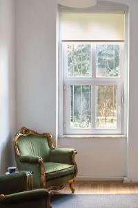 a green chair sitting in front of a window at Taksim square, galata tower historical flat in Istanbul