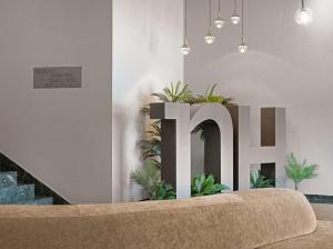 a room with a large letter h and plants at NH Ciudad de Cuenca in Cuenca