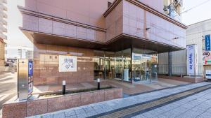 um grande edifício em uma rua da cidade com calçada em Toyoko Inn Marugame Ekimae em Marugame mais 33 fotografias