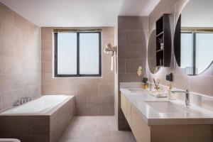 a bathroom with two sinks and a tub at TK Central Serviced Apartments in Phnom Penh +36 photos