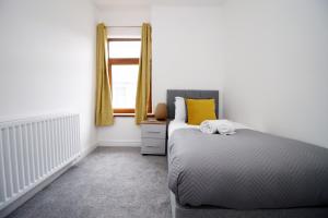a bedroom with a bed and a window at K Suites - Robert Street in Trehafod